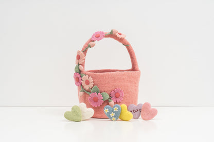 Pink felt basket with floral decorations and heart-shaped toys on a white background. fair trade kids gift | Global Goods Partners