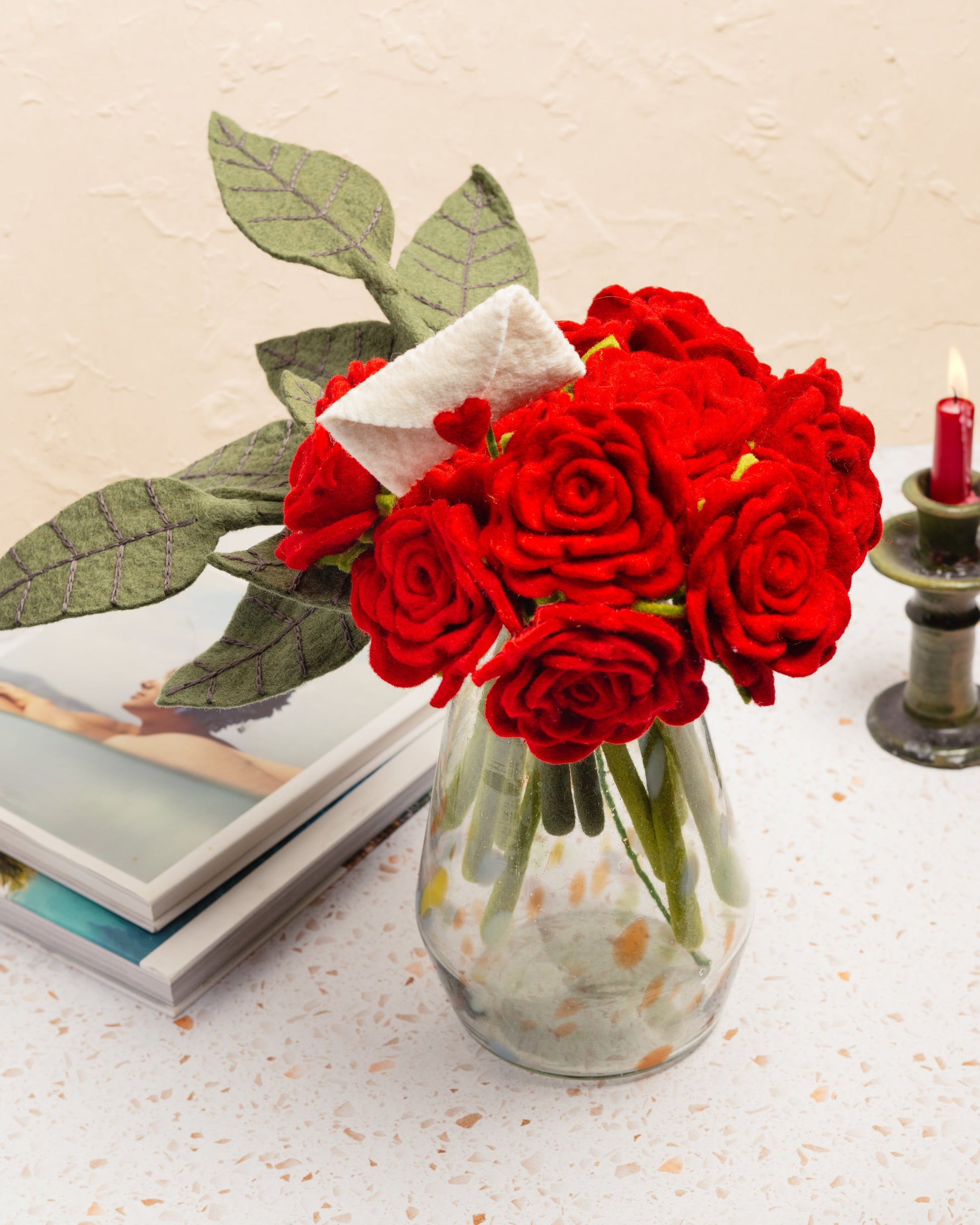 Felt red flower bouquet with accent stem of white envelope with red heart sealing the envelope..