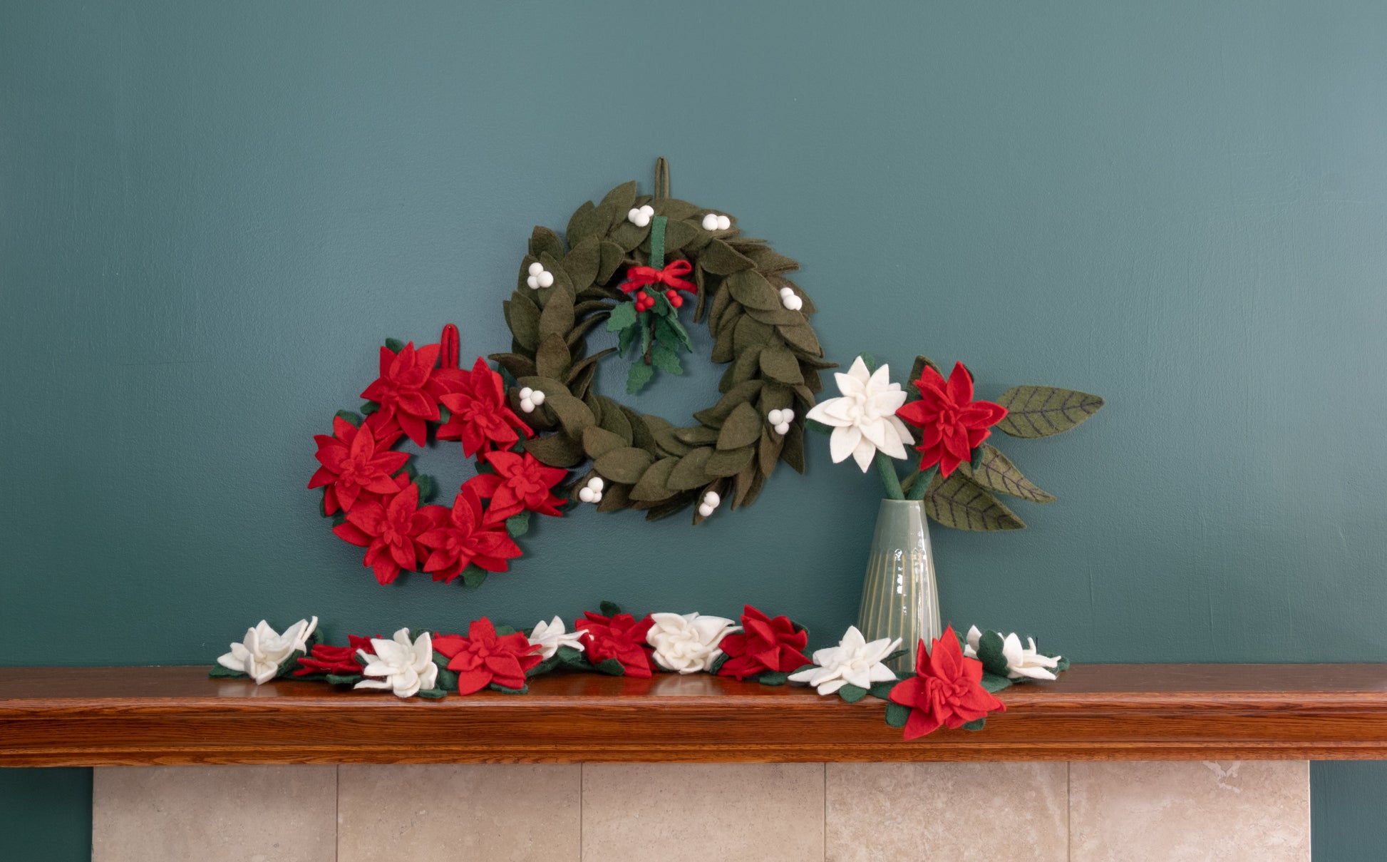 Felt ornament of Holly with berries and a red bow hanging with various wreaths.