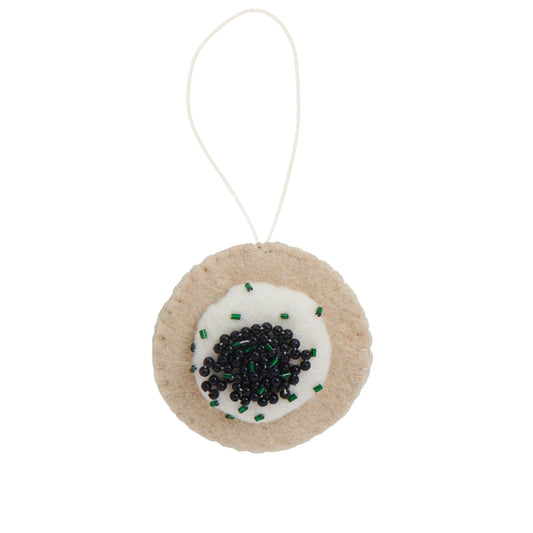 Felt ornament of caviar on a Blini with creme fraiche and chives.