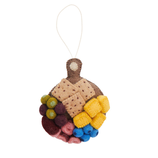 Felt ornament of a round charcuterie board with crackers, cheese, blueberries, salami, and grapes.
