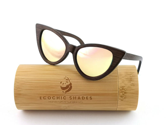 Dark brown bamboo cat eye sunglasses with pink mirrored lenses on cylindrical bamboo case.