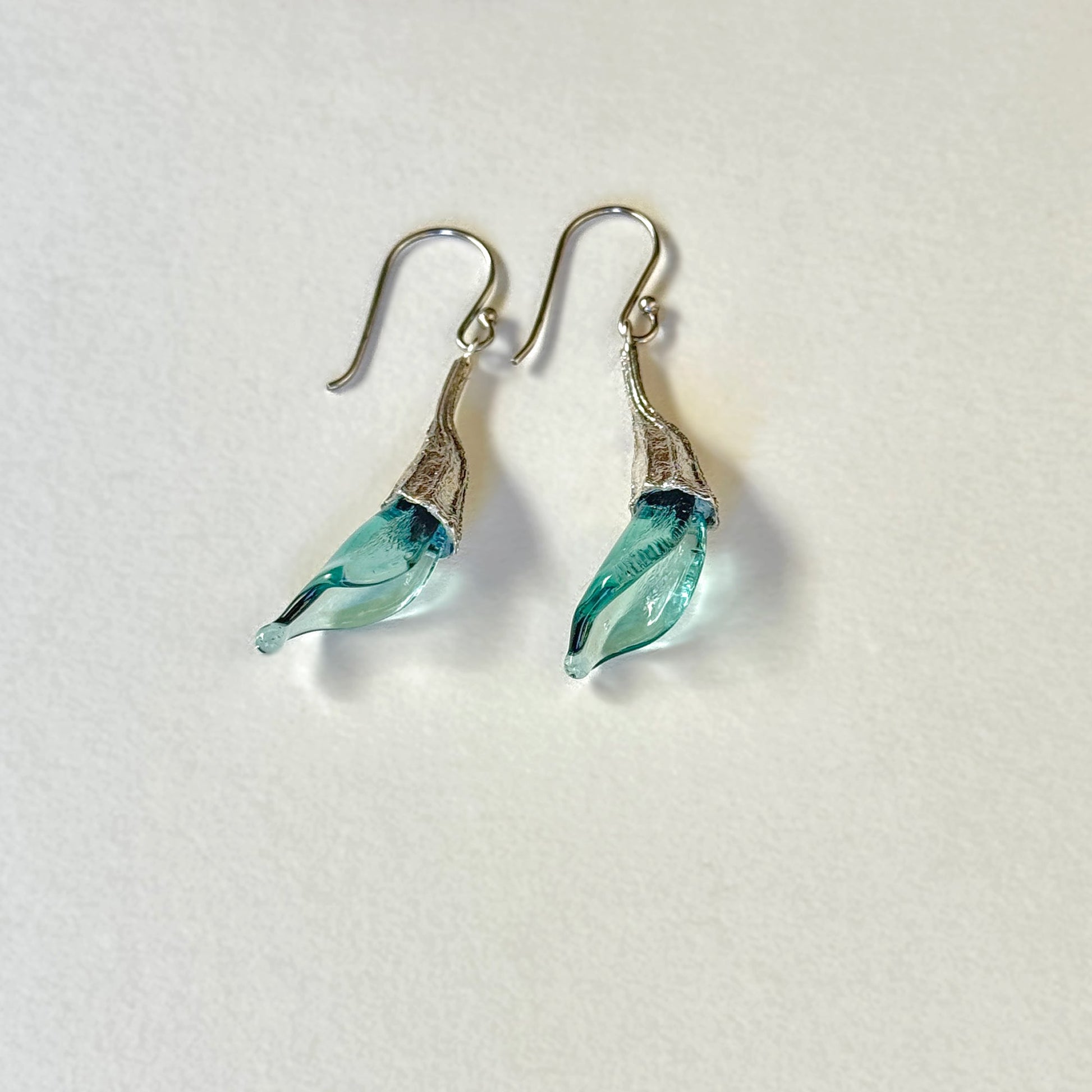 Pair of blue twisted glass petal earrings with silver findings.