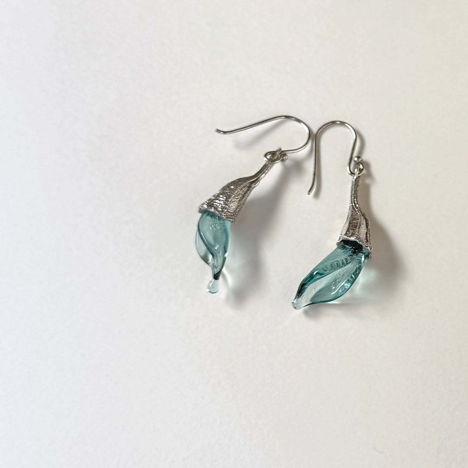 Pair of blue twisted glass petal earrings with silver findings.