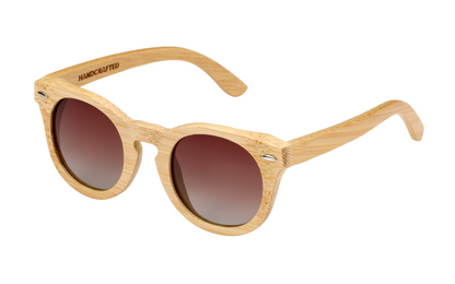 Diagonal view of natural tan bamboo sunglasses with round gradient amber tinted lenses.