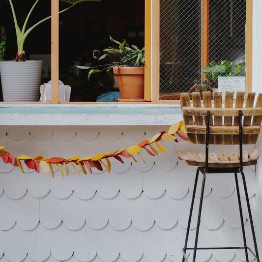 Felt garland of yellow, orange, and red fall leaves hanging below bar counter.