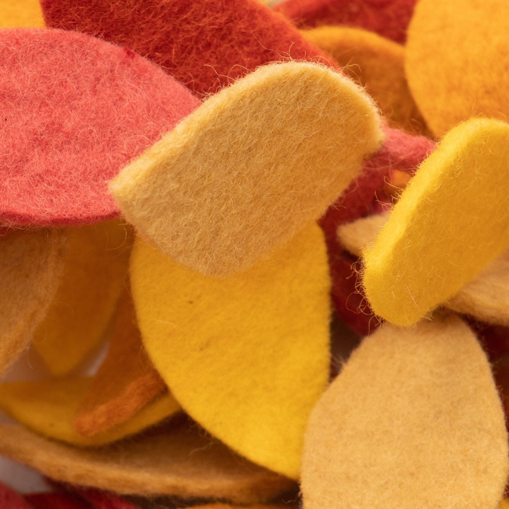 Close up of felt garland of yellow, orange, and red fall leaves.