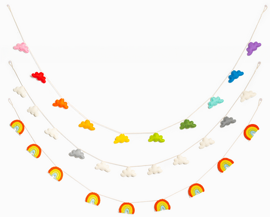 Three felted garlands hanging. The top garland of rainbow colored clouds, the middle white and grey clouds, and the bottom rainbows.