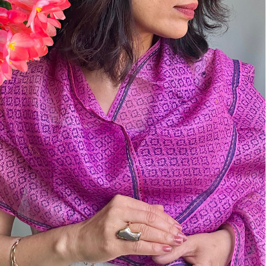 Pink Kota silk scarf in rose magenta with small block-printed floral motifs, draped around a model’s neck.