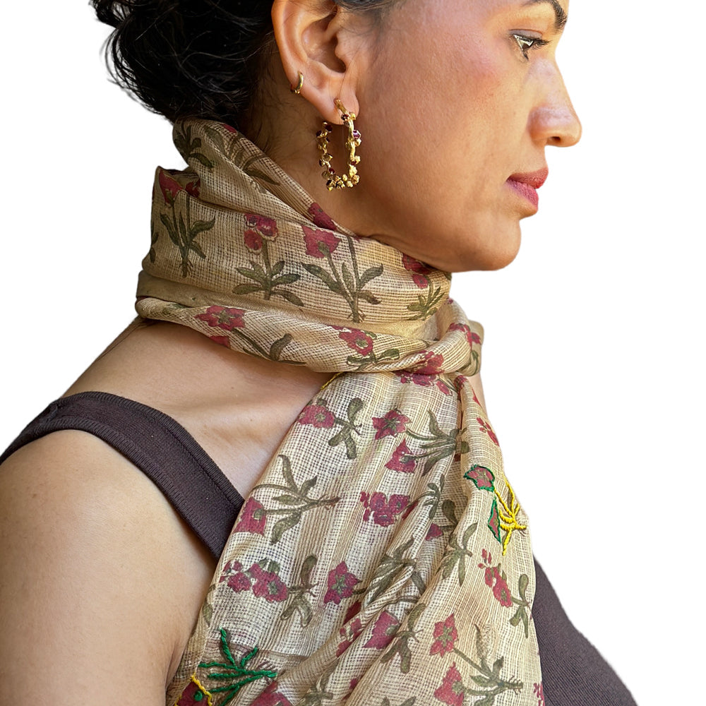 Right side view of woman wearing natural colored silk scarf with pink, green, yellow flowers.