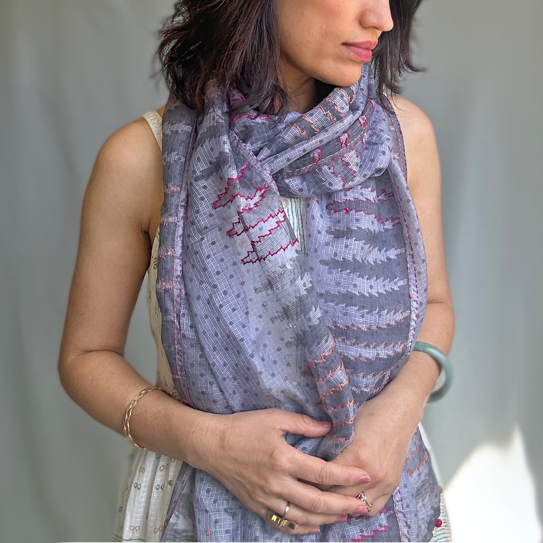 Woman wearing purplish grey stole with tree motif.  Includes pink outlining.