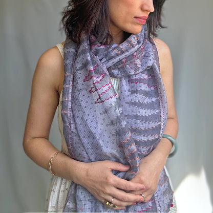 Woman wearing purplish grey stole with tree motif.  Includes pink outlining.