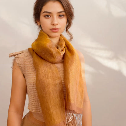 Rust orange handwoven linen scarf with gold zari metallic threads, dyed with natural myrobalan and tea, draped around a model’s neck.
