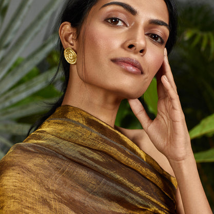Front view of woman wearing gold mandala earrings.