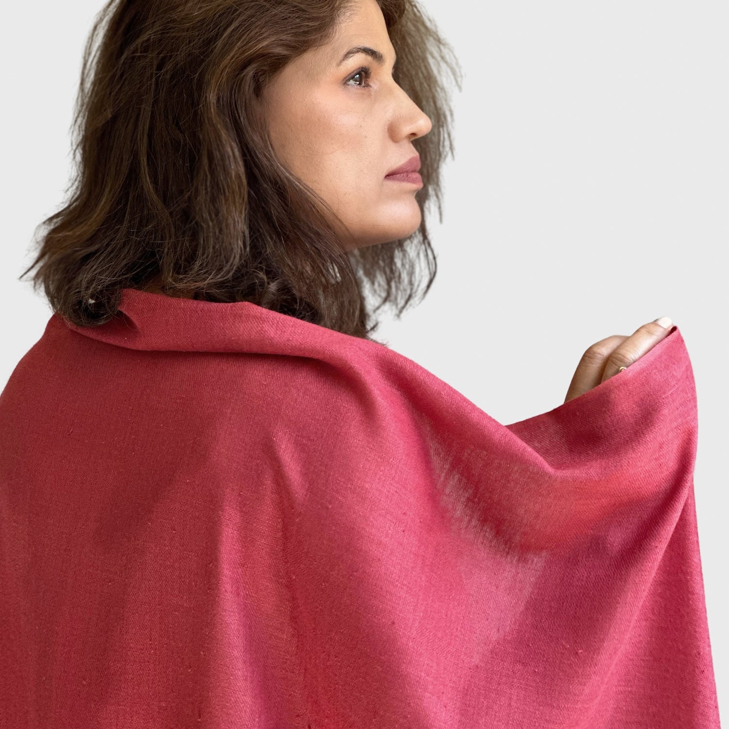 Back side view of silk scarf in pink draped over woman's back.