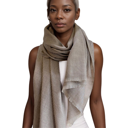 Partial view of woman wearing taupe and brown striped scarf, wrapped around neck.