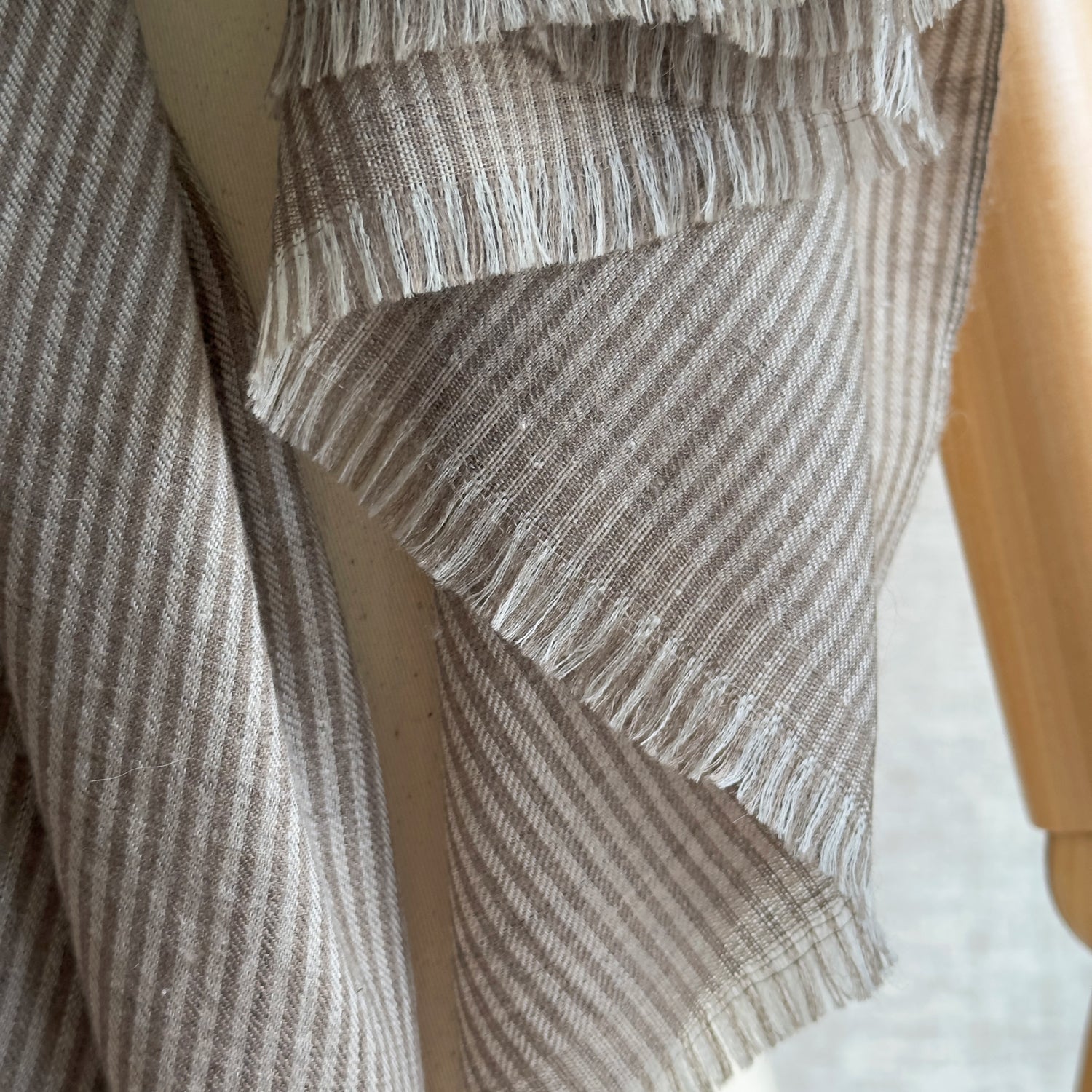 Closeup of taupe and brown striped scarf on manikin.