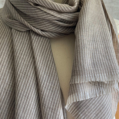 Closeup of taupe and brown striped scarf wrapped around neck.