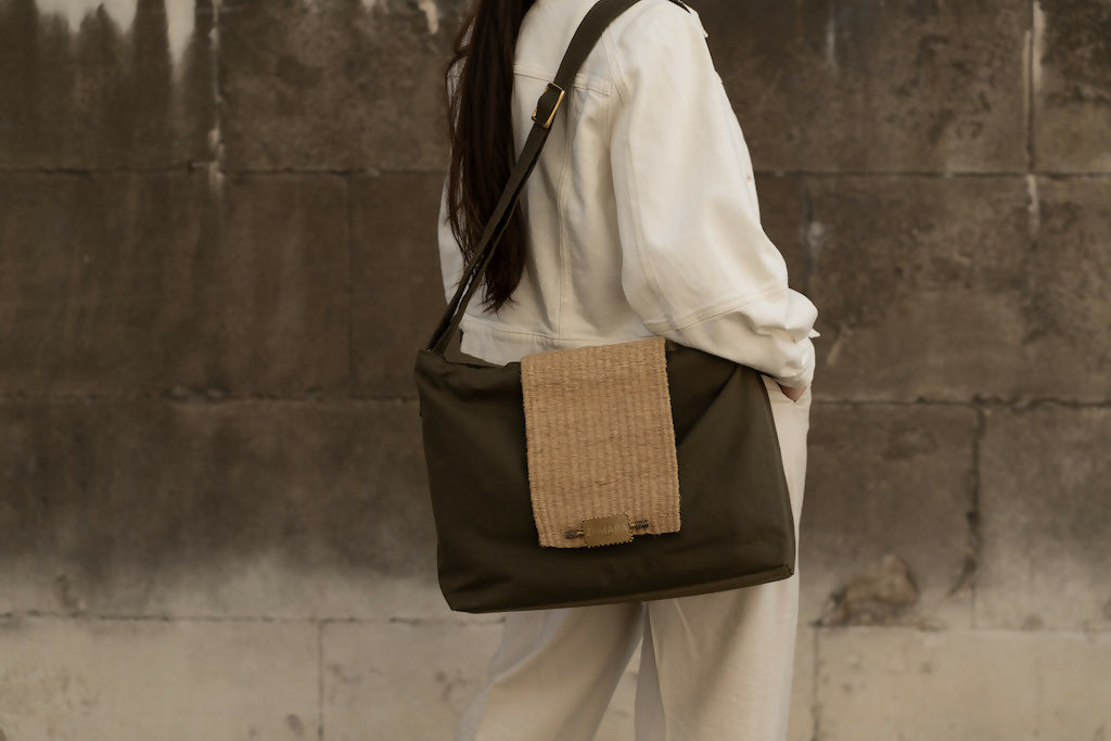 Partial back side view of woman and olive green bag with sisal details.