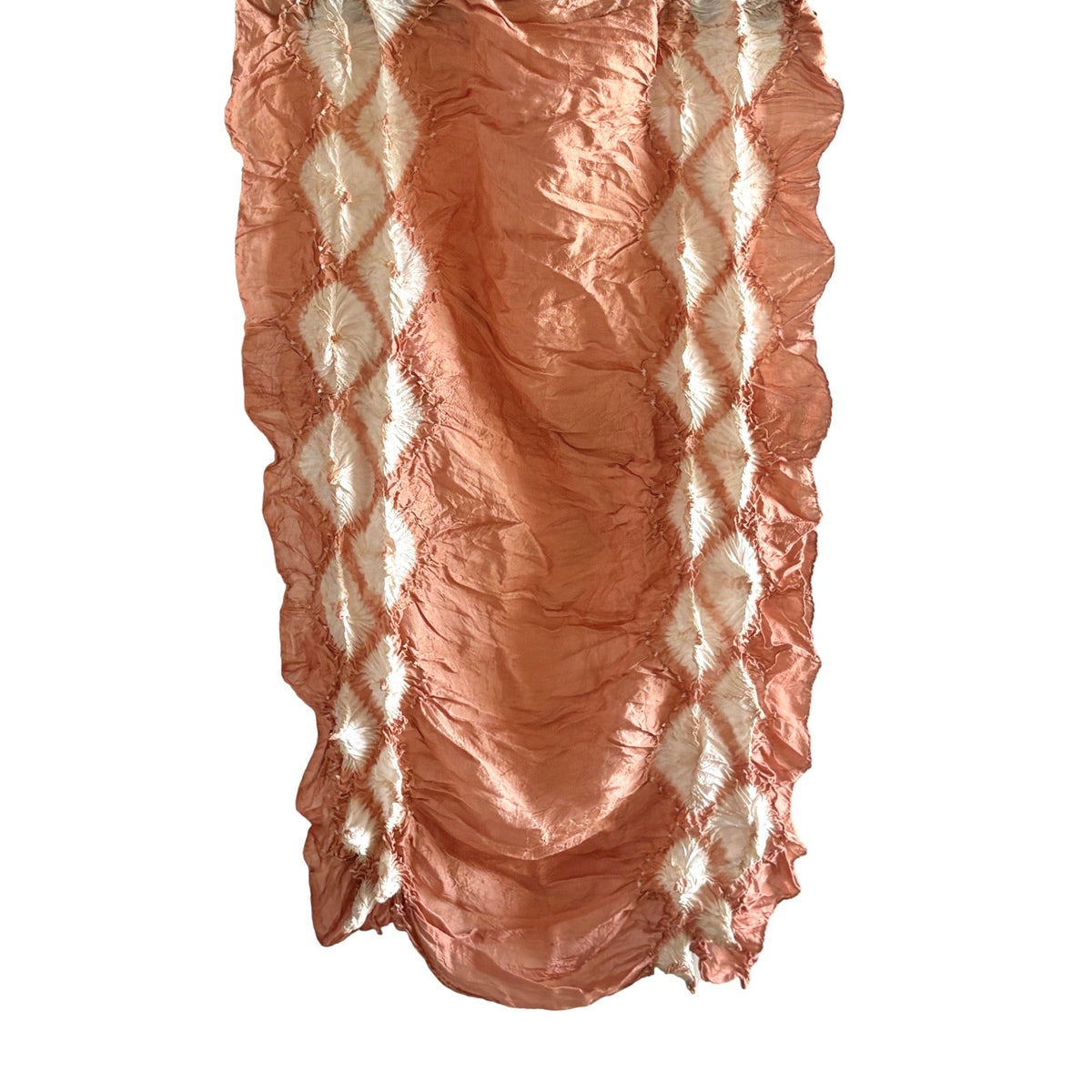 Natural sappanwood-dyed silk scarf in terracotta orange with white diamond shapes, hanging vertically on a white background.