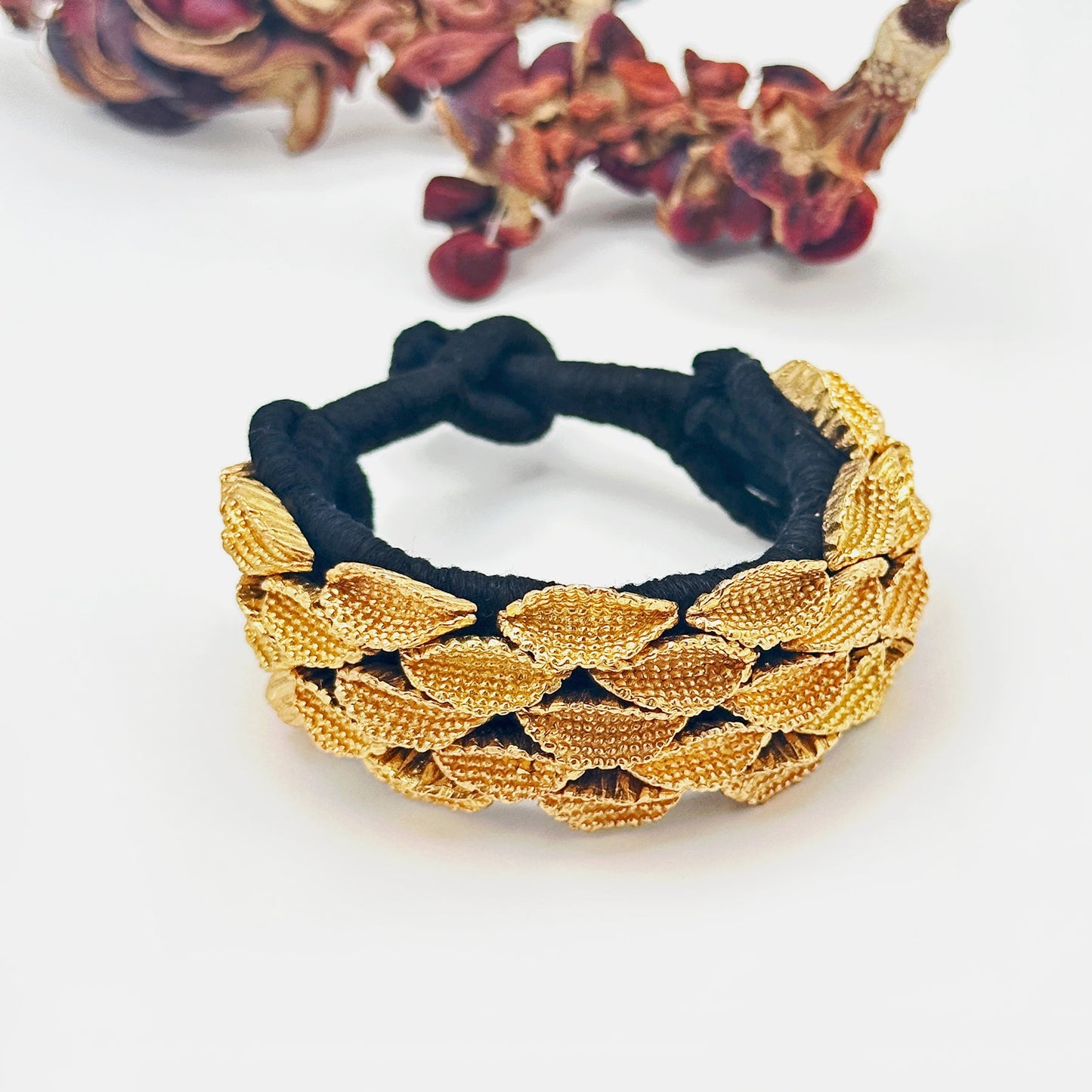 Seedpod bracelet with seedpods at top of image.