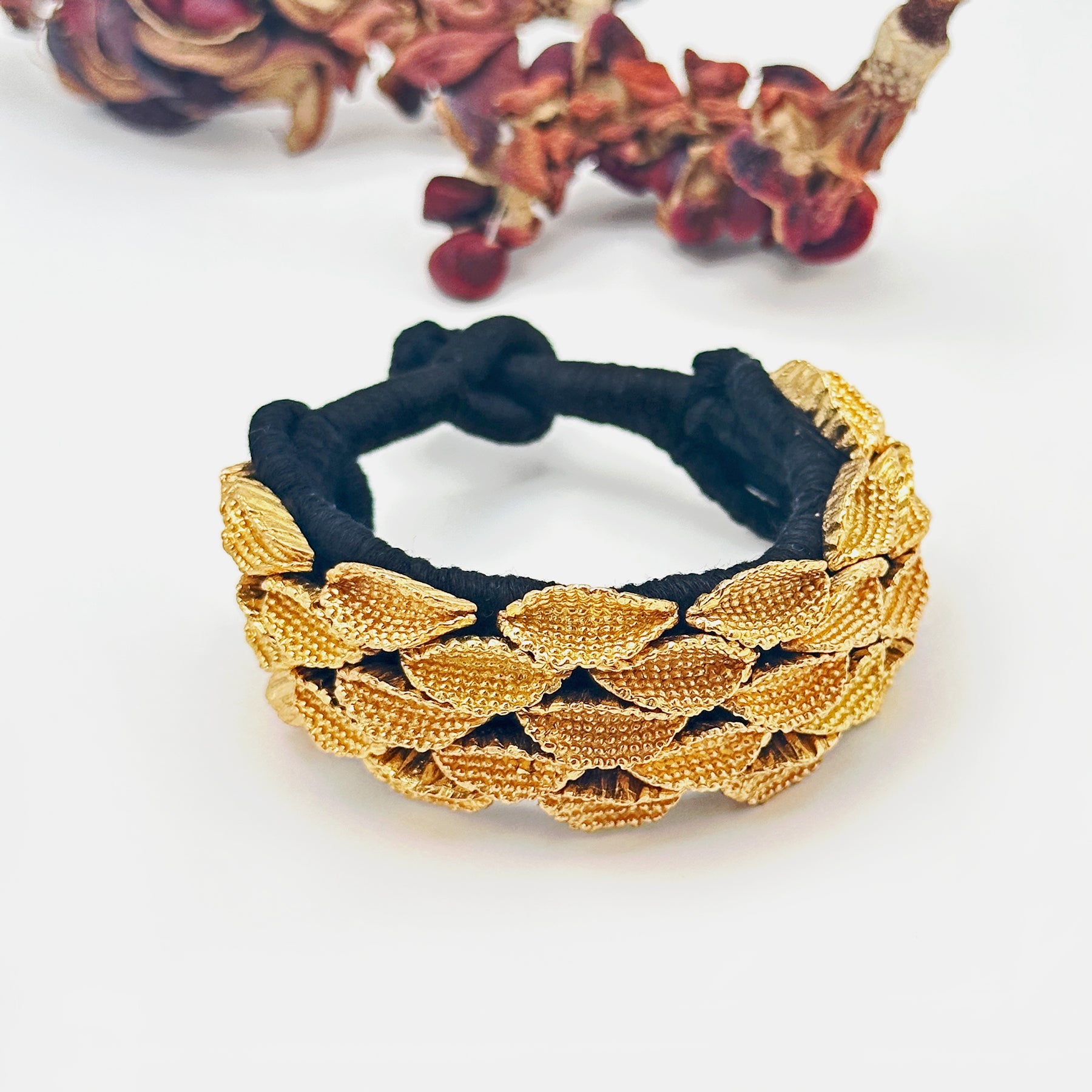 Seedpod bracelet with seedpods at top of image.