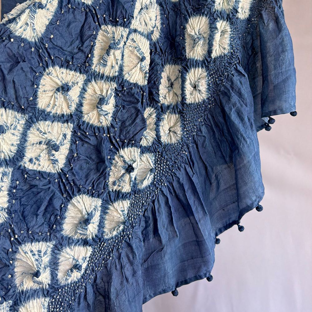 Close-up of dark blue indigo-dyed mulberry silk sari showing white diamond shibori fold-resist pattern on the pallu.