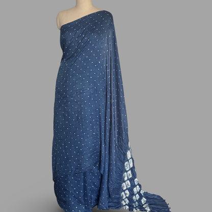 Dark blue mulberry silk sari dyed with natural indigo, with white bandhani dots and a shibori diamond pattern on the pallu, draped on a mannequin.