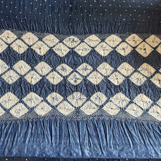 Close-up of dark blue indigo-dyed mulberry silk sari showing white diamond shibori fold-resist pattern on the pallu.