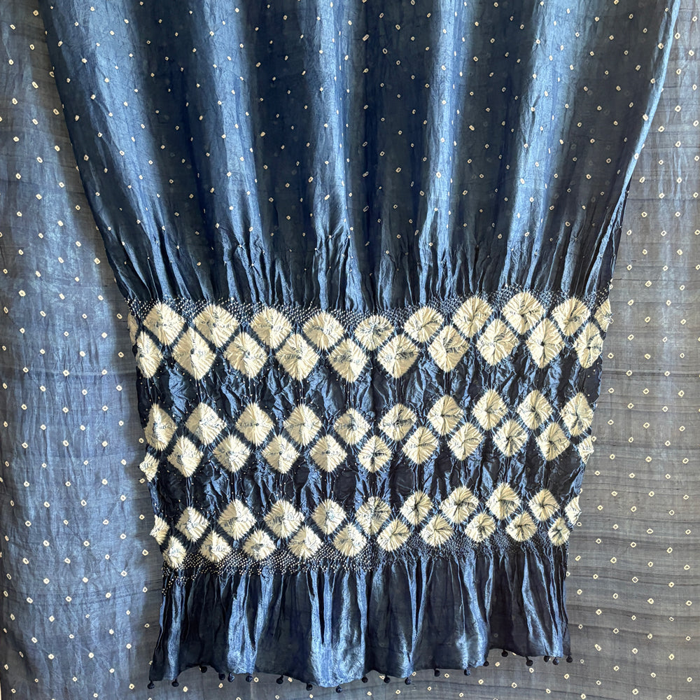 Close-up of dark blue indigo-dyed mulberry silk sari showing white diamond shibori fold-resist pattern on the pallu.
