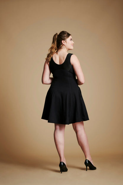 Back view of woman wearing black flare dress with scoop back.