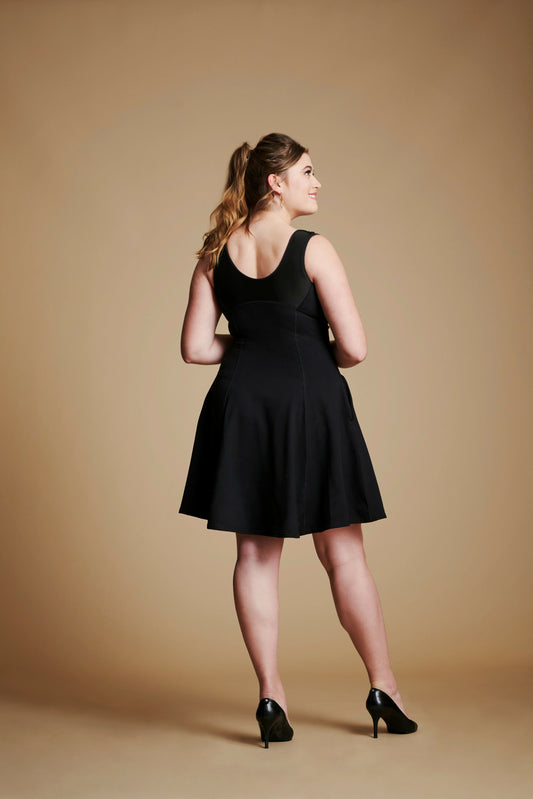 Back view of woman wearing black flare dress with scoop back.