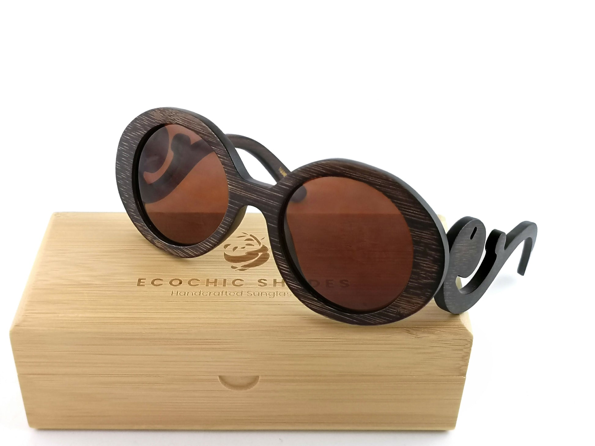 Brown bamboo sunglasses with brown lenses with scroll like design on arms on rectangular bamboo case.